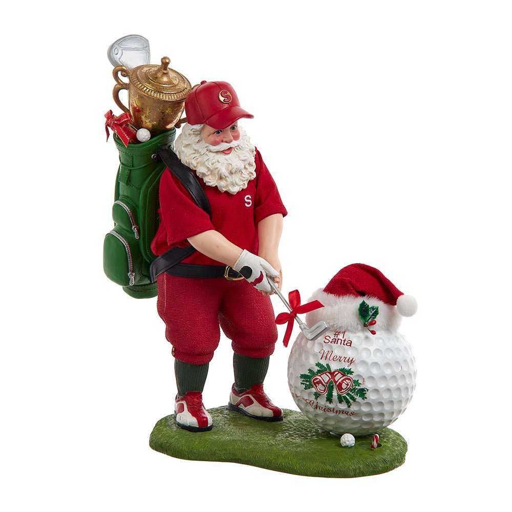 Santa Claus figurine holding a giant golf ball, standing on grass with golf club in hand