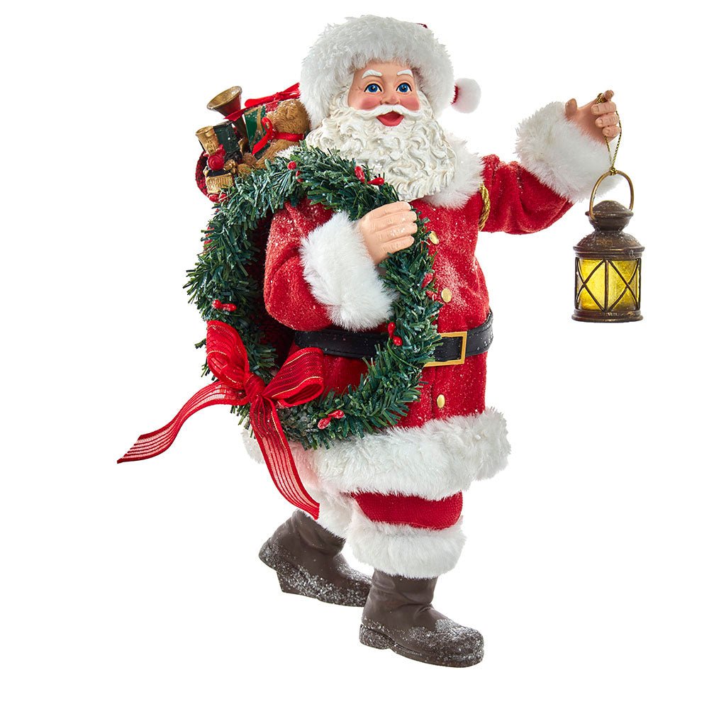 Holiday decoration featuring Fabriché™ Santa With Wreath and Lantern, 10.5 inches
